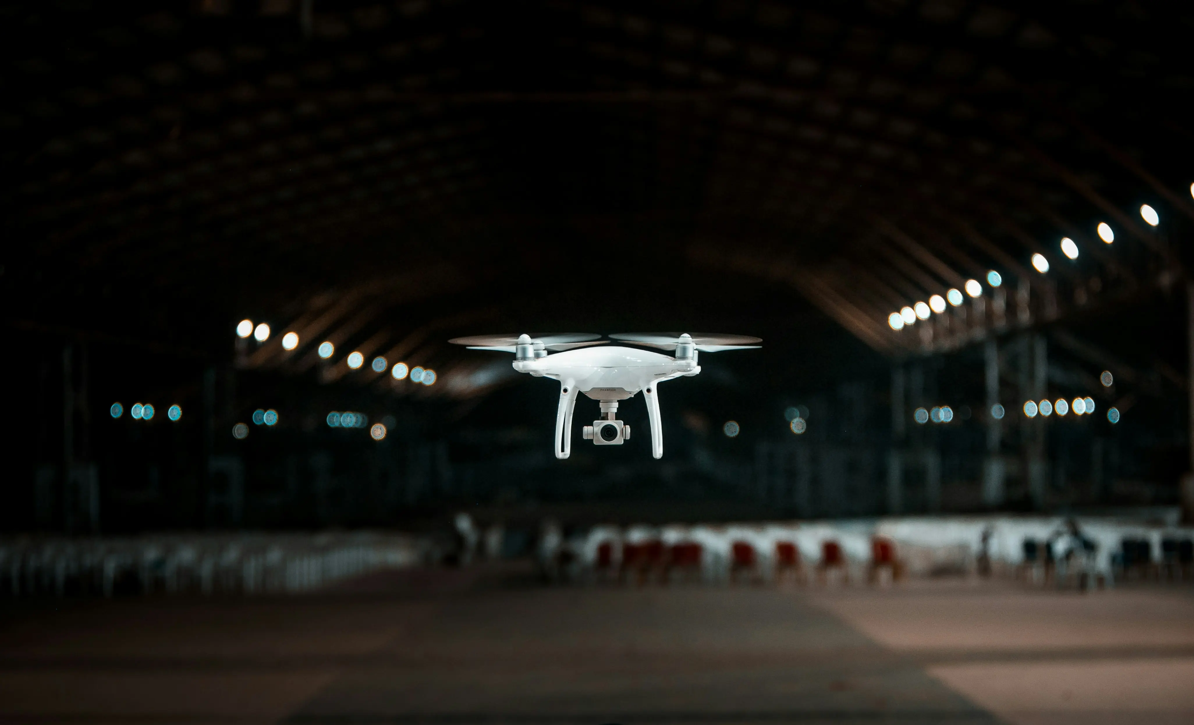 An industrial white drone flying inside a facility, demonstrating the deployment of compact drone weather station sensors for complex indoor and tunnel airflow monitoring.