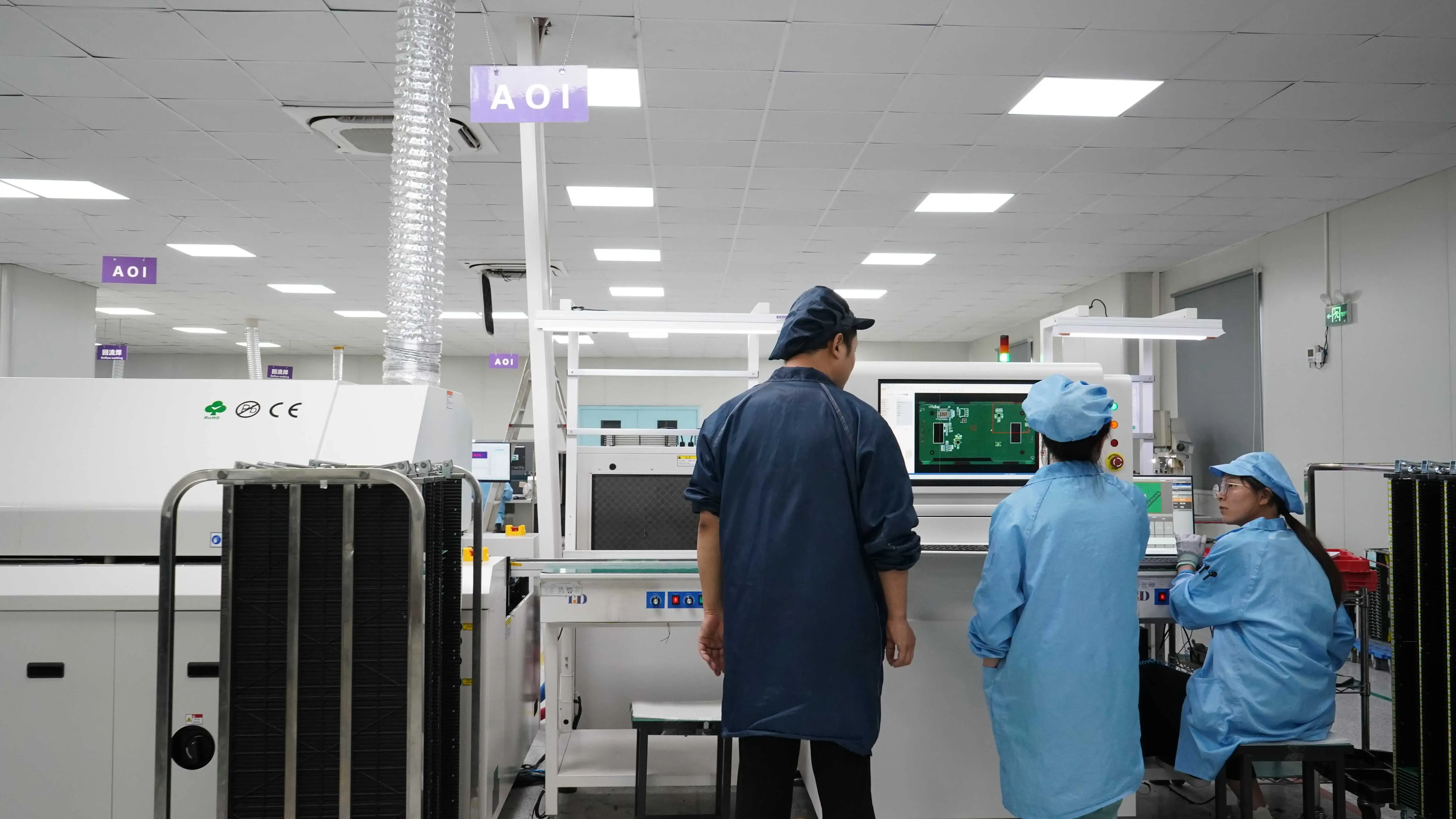 Senior electronic engineers discussing sensor circuit board specifications in Virtue's facility, demonstrating precise OEM manufacturing capabilities.